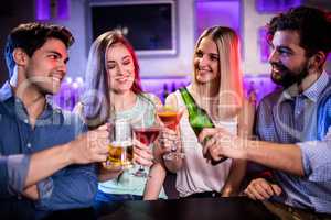 Group of friends toasting cocktail, beer bottle and beer glass a