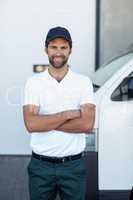 Portrait of delivery man is posing with crossed arms