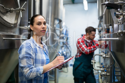 Female maintenance worker testing brewery machine
