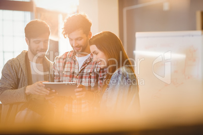 Graphic designer using digital tablet with his coworker