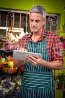 Male florist using digital tablet