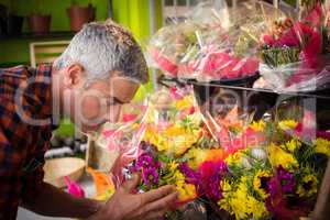 Male florist smelling flower