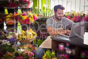 Male florist using laptop