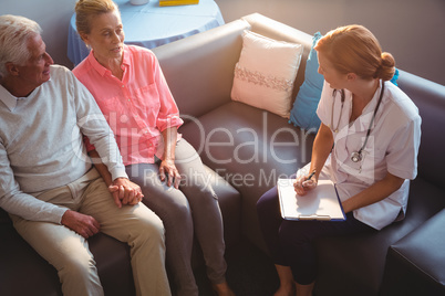 Nurse talking to senior couple