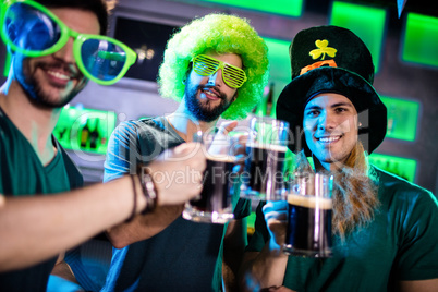 Male friends toasting beer mugs