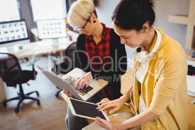 Two female graphic designer using digital tablet and laptop