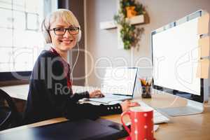 Female graphic designer working on computer and laptop