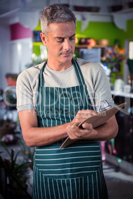 Male florist writing on clipboard