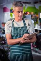 Male florist writing on clipboard