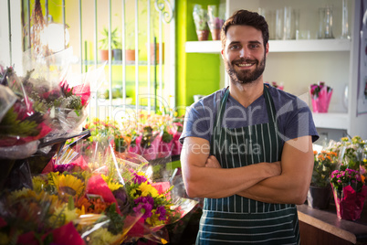 Male florist with arms crossed at his flower shop