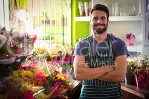 Male florist with arms crossed at his flower shop