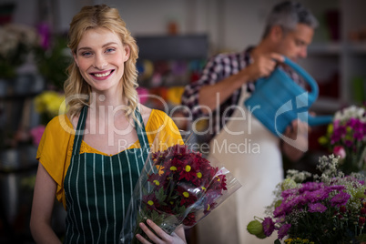 Happy female florist holding flower bouquet