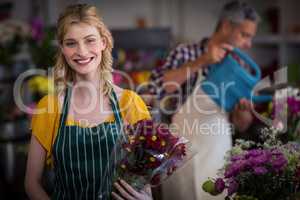 Happy female florist holding flower bouquet