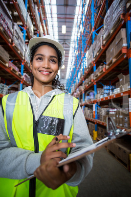 Smiling female worker holding clipboard