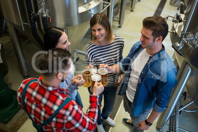 Brewers toasting beers at brewery