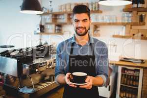 Portrait of man standing with a cup of coffee in office cafeteri