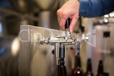 Brewer filling beer in bottle