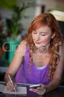 Female florist writing on notebook