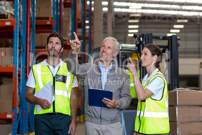 Manager and workers are looking shelves and pointing