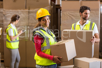 Focus of worker is holding goods and smiling to the camera