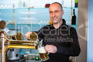 Bar tender filling beer from bar pump