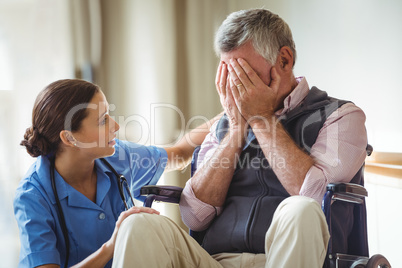 Nurse taking care of sad senior man