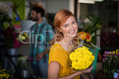 Portrait of female florist holding flower bouquet