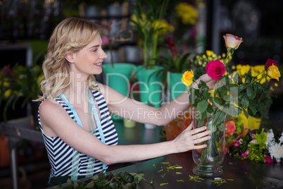 Female florist arranging flower bouquet in vase