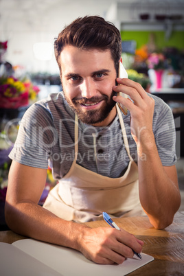 Male florist talking on mobile phone