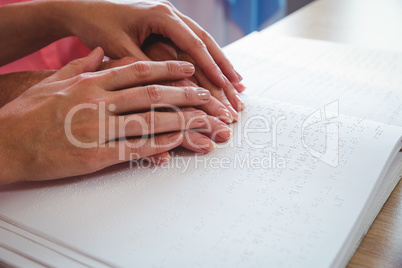 Nurse helping senior woman with braille