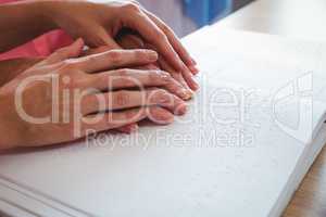 Nurse helping senior woman with braille