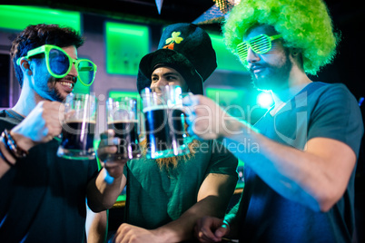 Male friends toasting beer mugs