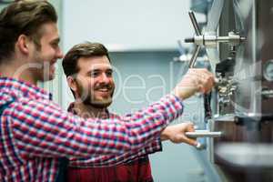 Maintenance workers examining brewery machine