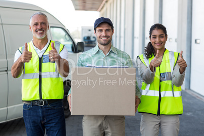 Portrait of workers are posing with thumbs up close to a deliver