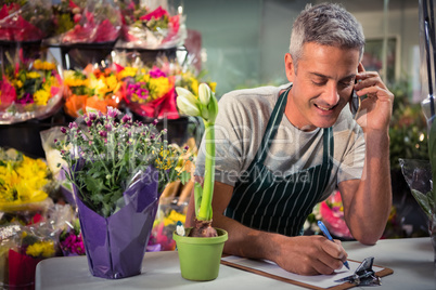 Male florist taking order on mobile phone