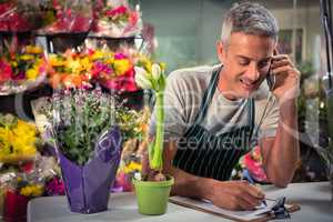 Male florist taking order on mobile phone