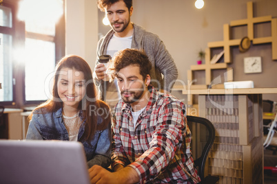 Graphic designer using laptop with his coworker