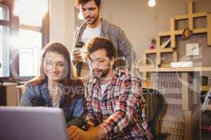 Graphic designer using laptop with his coworker