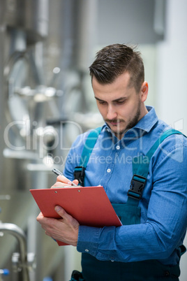 Maintaince worker wrting on clipboard