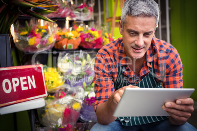 Male florist using digital tablet