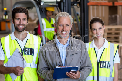 Portrait of manager is posing next to the workers and smiling