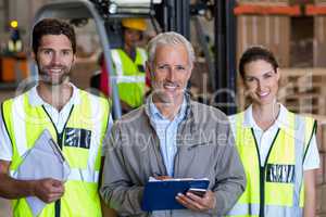 Portrait of manager is posing next to the workers and smiling