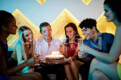 Group of smiling friends having a glass of champagne while celeb