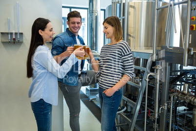 Brewers toasting beers at brewery