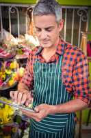 Male florist using digital tablet