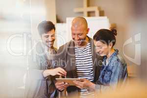 Graphic designer using digital tablet with his coworker