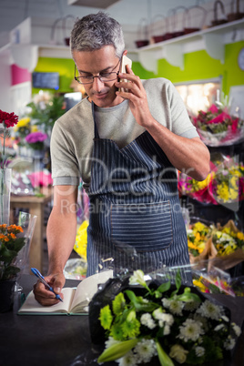 Male florist taking order on mobile phone