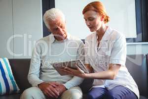 Nurse and senior man using a digital tablet