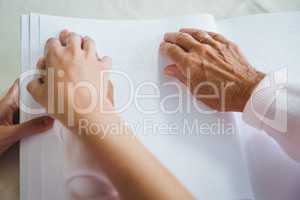 Nurse helping senior woman with braille