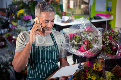 Male florist taking order on mobile phone